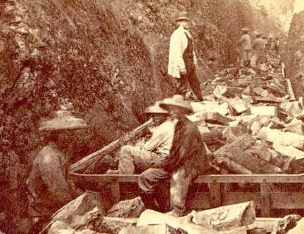 Chinese coolie labor being overseen by white man.
