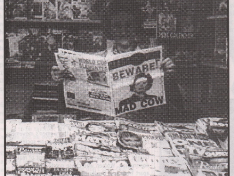 A newsagent reads a copy of Class War surrounded by other newspapers