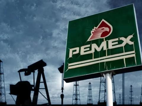 Pemex sign with oil field in the background