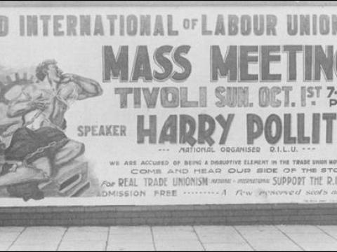 Harry Pollitt standing by a poster advertising a Harry Pollitt rally