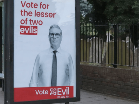 A vandalized or "détourned" election day poster for former U.K. Labor Party leader Keir Starmer who is featured on the right-side of it while the text to the left of him has been changed to say "Vote for the lesser of two evils" and the text on the horizontal red bar below him saying "Vote Evil" with "On July 4th" in smaller text below it.