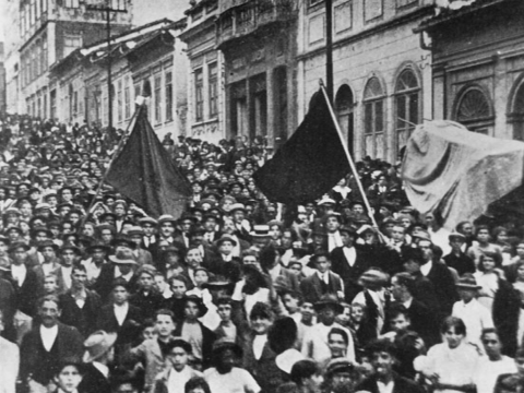 A black and white old picture of anarchists protesting with black flags