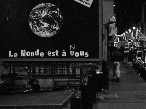 A billboard image of a globe with the slogan "le monde est a vous" "vous" has been altered to "nous"