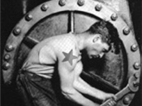 A proletarian working hard in a factory, with a red and black star tattoo