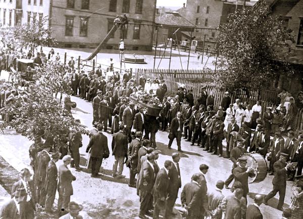 ‘A crowd of approximately 7,000 turn out on the streets of Virginia, Minnesota to view of the funeral procession of John Allars. Allars, a miner and member of the IWW, was murdered in his home by gunmen in the early morning hours of June 22, 1916 during the Mesaba Range Strike.’