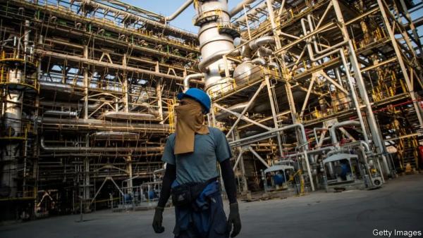 A worker with his face covered with a safety cloth walks through the Bushehr Petrochemical Co. plant during construction work in the Pars Special Economic and Energy Zone in Asaluyeh, Iran