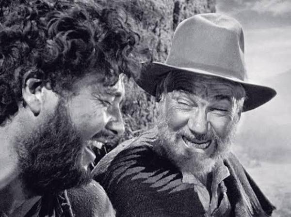 a scene from the movie Treasure of the Sierra Madre - two men laughing.