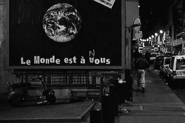 A billboard image of a globe with the slogan "le monde est a vous" "vous" has been altered to "nous"